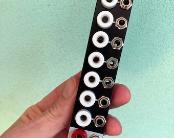May include: Black panel with eight white jacks and one red jack. The panel has the text "BANA NANA" printed on it. A small bear logo is at the bottom of the panel.
