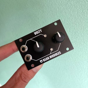 May include: A black electronic music module with two knobs and two jacks. The module is labeled "VOLTY" and "BEAR MODULES".