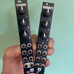 May include: Two black audio effect modules with knobs and jacks. The module on the left is labeled "STEREOMIX" and the module on the right is labeled "DUBBY2".