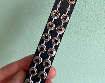 May include: Black Eurorack module with the text "BIG BUFF" in white lettering. The module has 16 silver jacks.