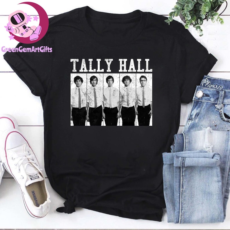 May include: Black T-shirt featuring the band name "TALLY HALL" in white block letters above a black and white image of the band members. The band members are wearing white shirts and ties. The shirt is displayed with a pair of jeans and white sneakers.