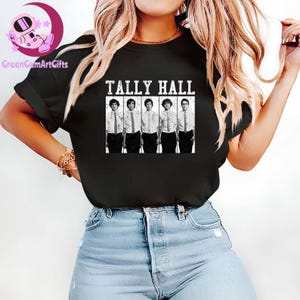 May include: Black T-shirt featuring the band name "TALLY HALL" in white block letters above a black and white image of the band members. The band members are wearing white shirts, ties, and black pants.