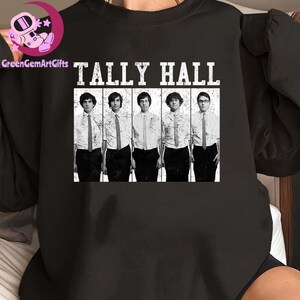 May include: Black crew neck sweatshirt featuring a graphic of the band Tally Hall. The graphic is a black and white image of the band members in shirts and ties. The band's name is printed above the image in bold, white letters.