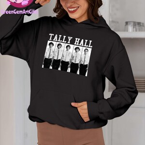 May include: Black hoodie featuring the text "TALLY HALL" above a black and white image of five people. The hoodie has a front pocket and a drawstring hood. The sleeves are long and the material appears to be a soft fabric.