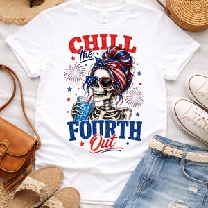 May include: White t-shirt with a graphic of a skeleton wearing sunglasses and a patriotic head wrap, drinking from a glass. The text "Chill the Fourth Out" is printed in red and blue. The image is surrounded by fireworks and stars.