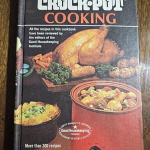 May include: A vintage cookbook titled "Crock-Pot Cooking" by Marilyn Neill. The cover features a roasted chicken, vegetables, and a red Crock-Pot slow cooker. The book promises over 300 recipes and is endorsed by Good Housekeeping.