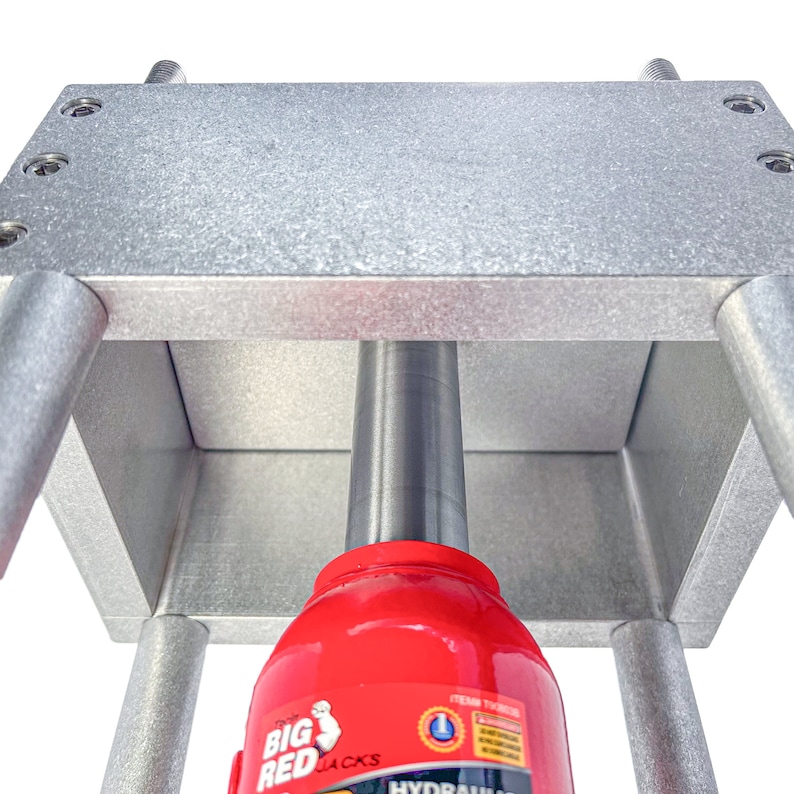 May include: A silver metal frame with a red hydraulic jack inside. The jack is labeled "Big Red Jacks" and "Hydraulic" with a white and blue logo.
