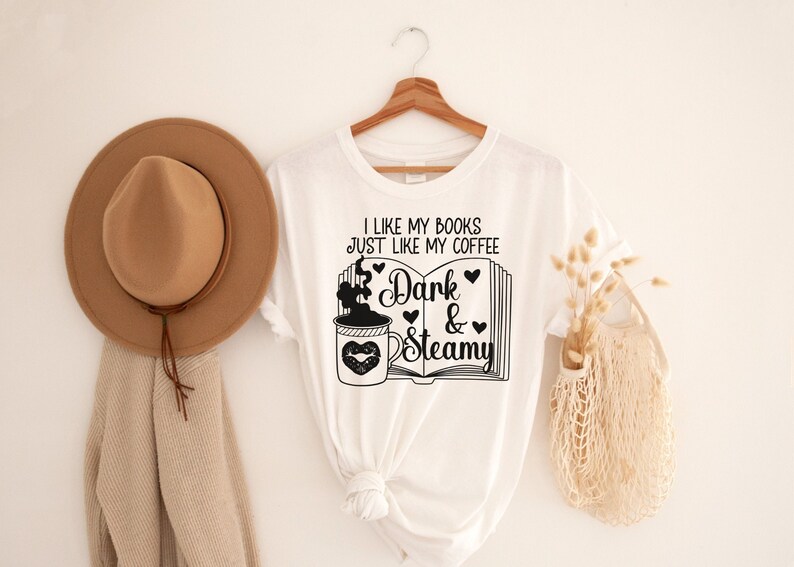 May include: White t-shirt with black text that reads "I like my books just like my coffee Dark & Steamy" with a graphic of a coffee cup and a book.