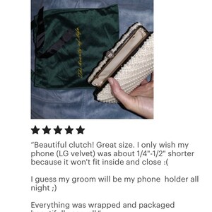 Peut inclure: Une pochette de soir&eacute;e blanche en perles avec une fermeture dor&eacute;e et un petit bijou en perle. La pochette est ouverte et l'int&eacute;rieur est doubl&eacute; d'un tissu beige clair. La pochette est pos&eacute;e sur un sac en velours vert avec les mots "The beauty of life" brod&eacute;s en fil d'or.