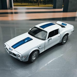 May include: A white model car with blue racing stripes and accents. The car has a sleek design with detailed features, including wheels, headlights, and a spoiler. The car is a classic muscle car.