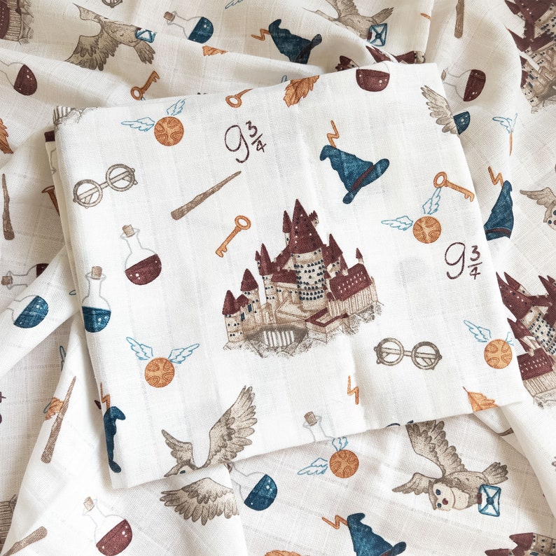 May include: White fabric with a Harry Potter theme. The fabric features a variety of images, including Hogwarts castle, a golden snitch, a lightning bolt, and the words "9 3/4".