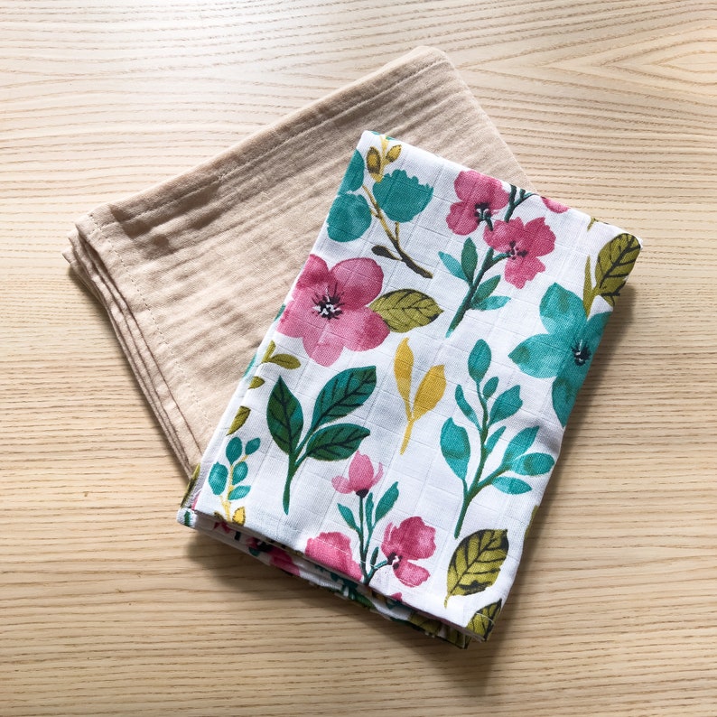 May include: Two fabric squares, one beige and one white with a floral pattern in shades of pink, teal, and yellow.