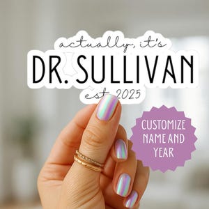 May include: A white sticker with the text "actually, it's DR. SULLIVAN est 2025" in black. A purple starburst graphic reads "Customize Name and Year". The sticker is held by a hand with iridescent nails and gold rings.