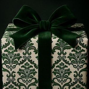Puede incluir: Una caja de regalo cuadrada envuelta en papel crema con un patrón de damasco verde. Está atada con una cinta y un lazo de terciopelo verde oscuro. La caja se presenta sobre un fondo verde oscuro.