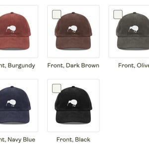 May include: A collection of baseball caps in various colors: burgundy, dark brown, olive, navy blue, and black. Each cap features a white kiwi bird logo on the front. The caps have a curved brim and an adjustable strap.