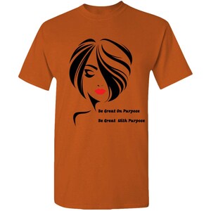 May include: Orange t-shirt with a black silhouette of a woman's face and the text "Be Great On Purpose" and "Be Great With Purpose".