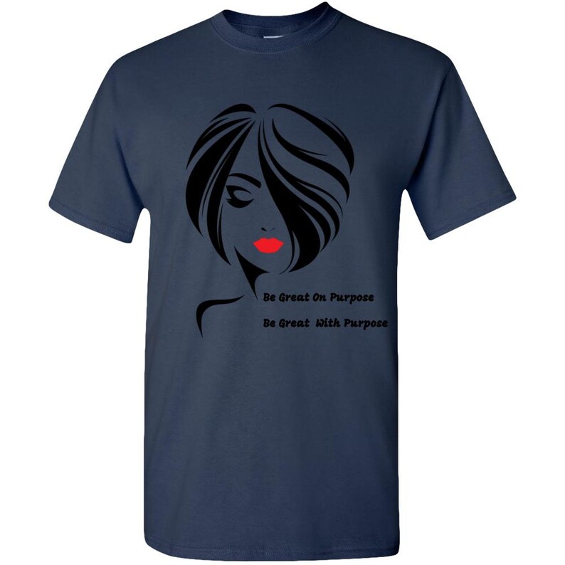 May include: Navy blue t-shirt with a black silhouette of a woman with red lips. The text "Be Great On Purpose" and "Be Great With Purpose" is printed below the silhouette.