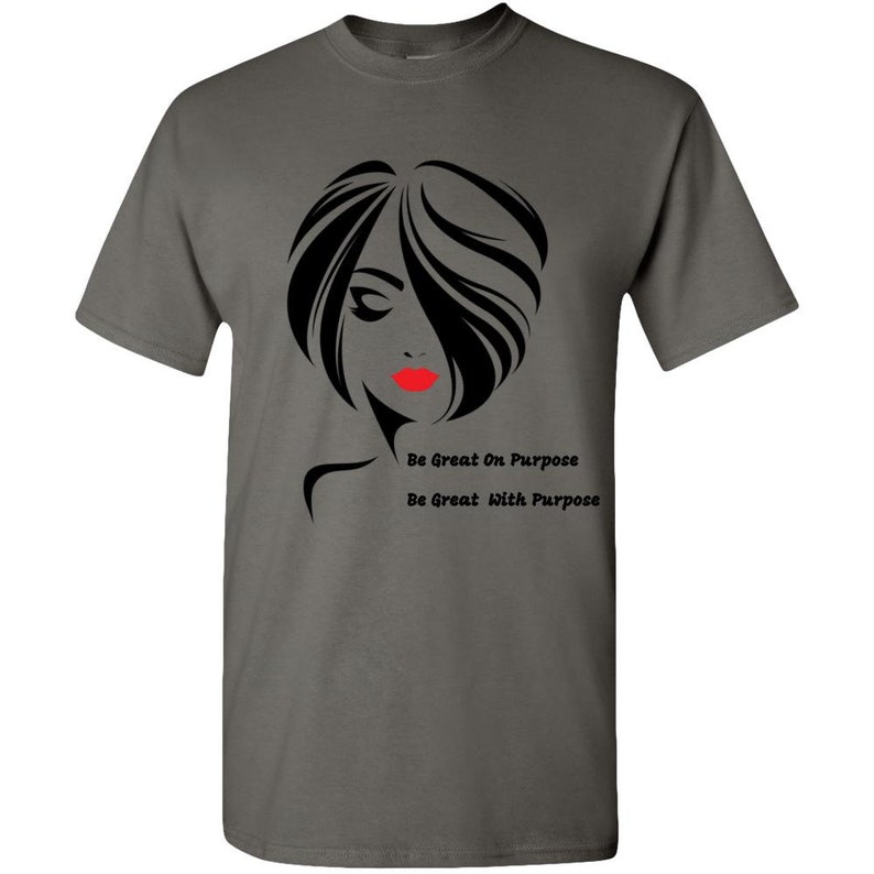 May include: A dark gray t-shirt with a black and white silhouette of a woman with red lips. The text "Be Great On Purpose" and "Be Great With Purpose" is printed below the silhouette.
