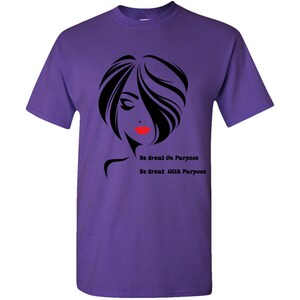 May include: Purple t-shirt with a black silhouette of a woman with red lips and the text "Be Great On Purpose" and "Be Great With Purpose".