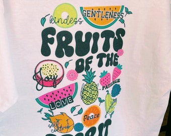 May include: White t-shirt with a colorful graphic of fruits and the text "Fruits of the Spirit" with words like "love", "joy", "peace", "kindness", "gentleness", "patience", and "self control" around the fruits.