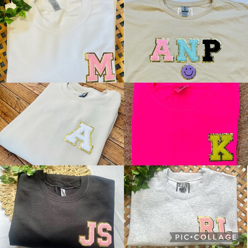 May include: Five different sweatshirts with large, colorful letters on the front. The letters are made of felt and have a glittery finish. The sweatshirts are in various colors, including white, beige, pink, black, and gray.