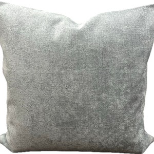 May include: A soft, gray throw pillow with a textured fabric. The pillow is square and has a subtle sheen.