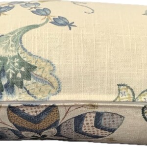 Puede incluir: Una almohada beige con un patr&oacute;n floral en tonos azules, verdes y marrones. La almohada tiene una cremallera.
