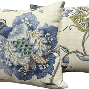 Puede incluir: Dos almohadas decorativas con un patr&oacute;n floral. Las almohadas son de color crema con dise&ntilde;os florales azules, verdes y marrones.