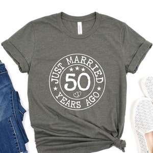 May include: A gray t-shirt with a white circle graphic that says "Just Married 50 Years Ago".