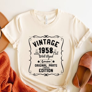 May include: A white t-shirt with a vintage-style graphic that says "Vintage 1958 Well Aged Genuine Original Parts Limited Edition". The graphic is in black and has a star design.