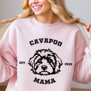 May include: Pink sweatshirt with a black graphic of a Cavapoo dog and the text "Cavapoo Mama Est. 2023".