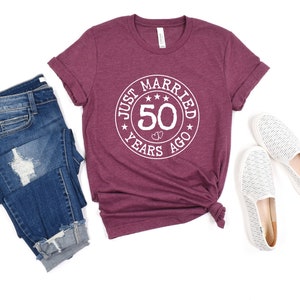 May include: A maroon t-shirt with a white circle graphic that says "Just Married 50 Years Ago".