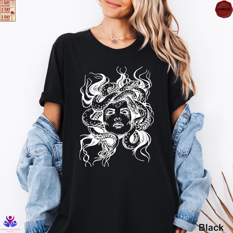 Pode incluir: Camiseta preta com um gr&aacute;fico branco do rosto da Medusa com cobras como cabelo. O desenho est&aacute; centrado na camiseta. A palavra "Black" est&aacute; impressa no canto inferior direito.