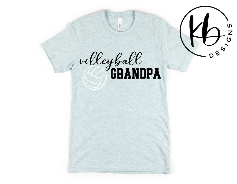 K&ouml;nnte beinhalten: Hellblaues T-Shirt mit schwarzem Text "Volleyball Grandpa" und einer wei&szlig;en Volleyballgrafik.