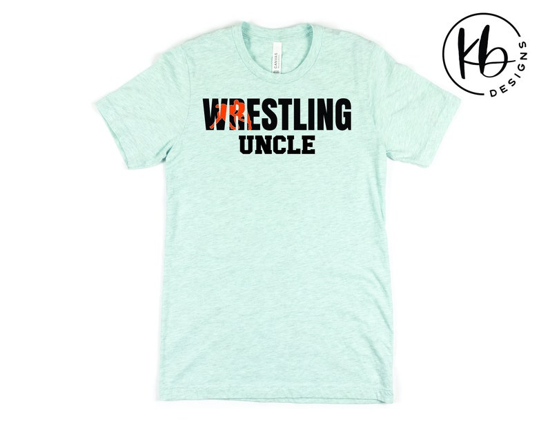 May include: A light blue t-shirt with the text "Wrestling Uncle" in black letters. The word "Wrestling" has a red and black wrestler graphic.