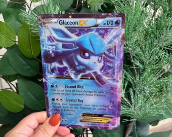 May include: A Glaceon EX Pokemon card with a blue and white Glaceon illustration. The card has a purple background with snowflakes and the text "Second Bite" and "Crystal Ray".