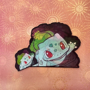 May include: A green and blue cartoon character with red eyes and a toothy grin. The character is in a leafy setting.