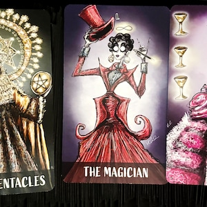 Puede incluir: Tres cartas de tarot con ilustraciones de inspiraci&oacute;n g&oacute;tica. La carta del Rey de Pent&aacute;culos presenta una figura con una t&uacute;nica dorada, una corona y un pentagrama. La carta del Mago presenta una figura con un vestido rojo y un sombrero de copa. La carta del Cuatro de Copas presenta una figura con un vestido rosa sosteniendo una copa dorada.