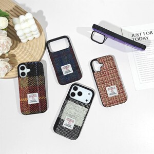 May include: Four smartphone cases featuring textured wool-like fabric in various plaid patterns, including red, yellow, blue, and grey tones. Each case displays a small rectangular white label with the text Harris Tweed. One case is shown from the side.