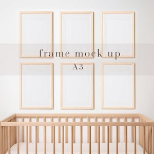 May include: Five wooden picture frames with white mats, arranged in a row on a white wall above a wooden crib. The frames are all the same size and are labeled "frame mock up A3".