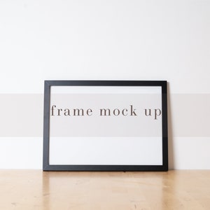 May include: A black picture frame with a white mat and the text "frame mock up" in the center.
