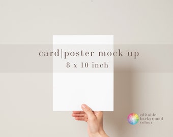 May include: A white card or poster mockup held in a hand against a light beige background. The card is 8 x 10 inches. The text "card|poster mock up" and "8 x 10 inch" is printed on the background.
