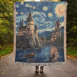May include: A woven tapestry featuring a whimsical depiction of Hogwarts castle, inspired by Vincent van Gogh's Starry Night. The castle is set against a swirling blue sky with yellow stars and a crescent moon. The scene includes a river flowing in front of the castle and a bridge.