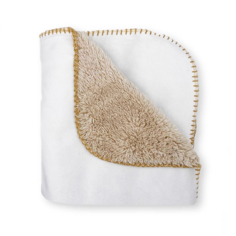 May include: A white fleece blanket with a brown faux fur lining. The blanket has a gold stitched border.