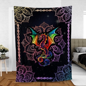 Può includere: Un arazzo con un drago arcobaleno con le ali spiegate, su uno sfondo nero con un motivo a mandala e un cielo stellato. Il mandala è bordato d'oro e viola.
