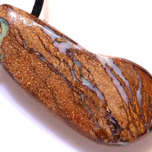 May include: A brown and white opal pendant with a leather cord. The opal has a unique pattern of white and blue streaks.