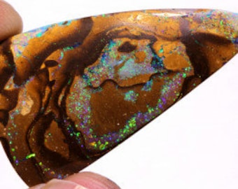 May include: A large, irregularly shaped piece of opal with a brown, orange, and green base. The opal has a strong iridescent sheen with flashes of blue, purple, and green.