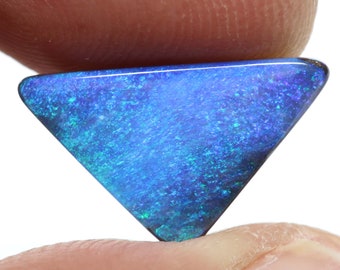 May include: A triangular blue opal gemstone with a shimmering, iridescent surface.