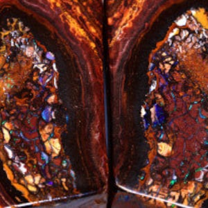 Könnte beinhalten: Nahaufnahme eines polierten, gespaltenen Edelsteins, der komplizierte Muster zeigt. Der Stein weist eine Mischung aus Braun-, Orange- und Goldtönen mit schillernden Blitzen von Blau und Lila auf. Die Oberfläche des Edelsteins ist glatt und zeigt eine komplexe innere Struktur.