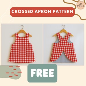 May include: Two red and white gingham aprons are displayed on wooden hangers. One apron is shown from the front, and the other from the back, with crossed straps. The text "CROSSED APRON PATTERN" is at the top, and "FREE" is at the bottom.